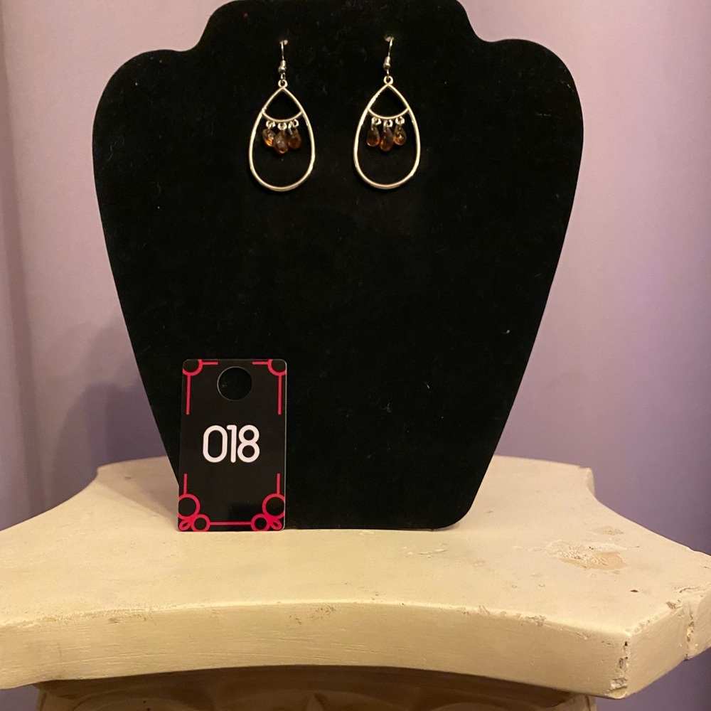 The earrings are attractive silver color teardrop w/ beautiful amber color gems
